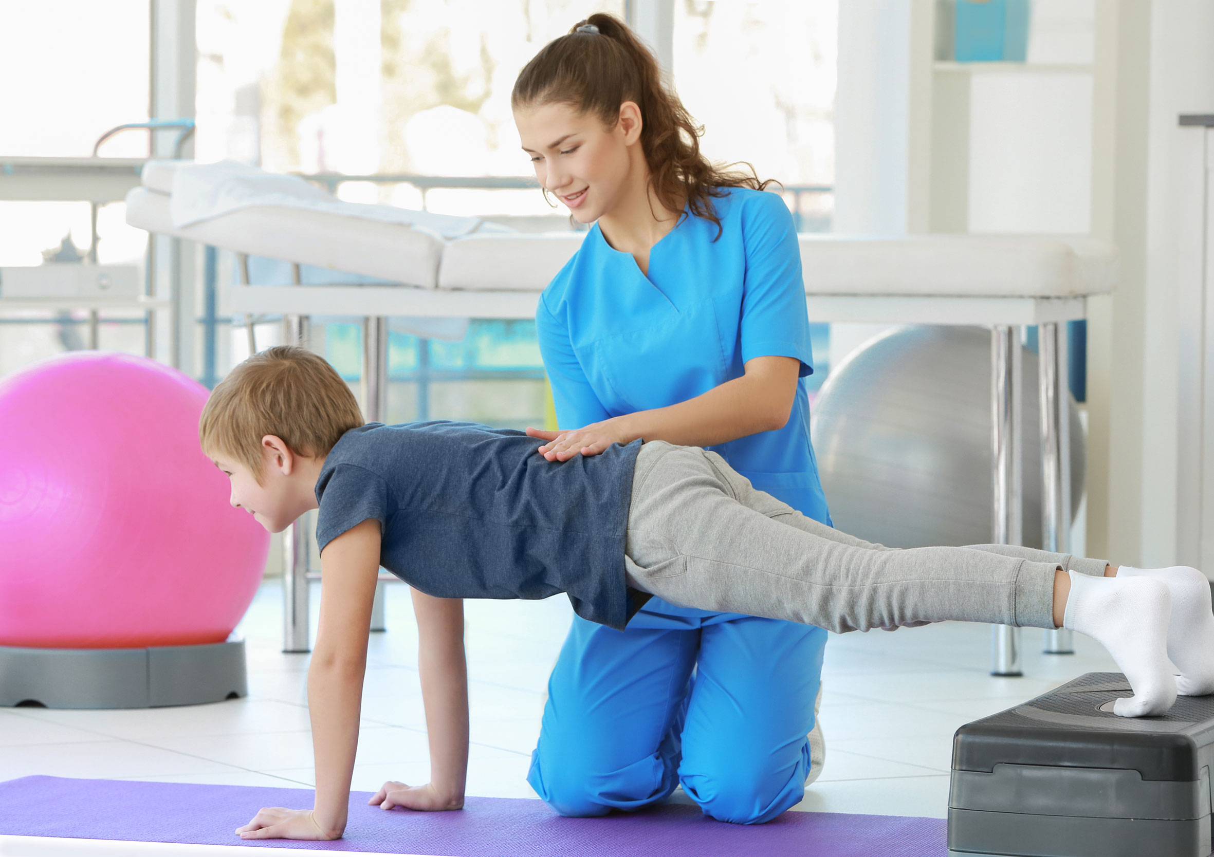 Eine Person in Blau erhält von einer anderen im Therapiezentrum Reform eine vorsichtige Nackendehnung.